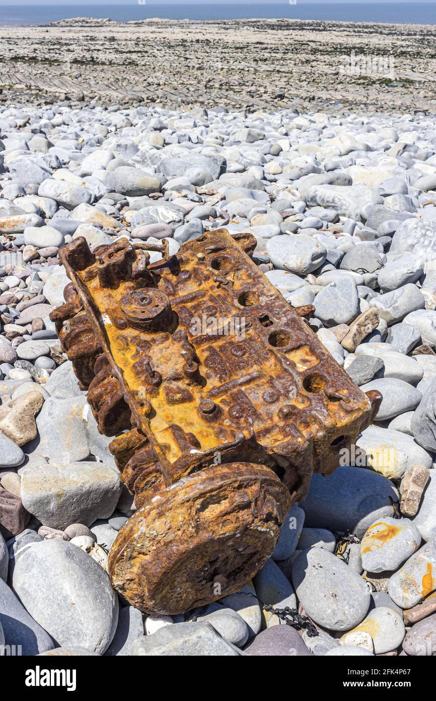 Die rostigen Überreste eines Fahrzeugmotors am steinigen Strand von Kilve, Somerset, Großbritannien Stockfoto