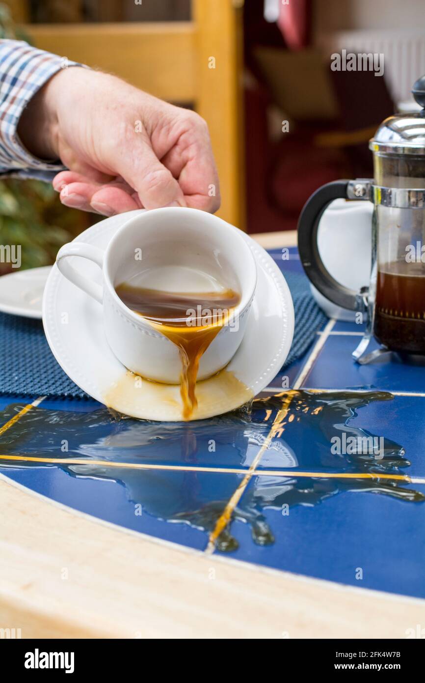Tasse Kaffee verschüttet auf einem Tisch Stockfoto