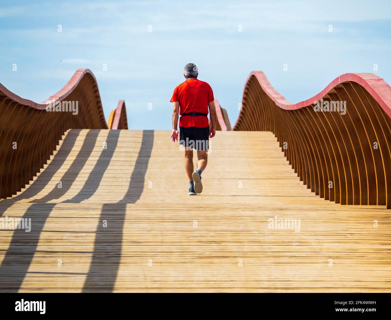 Athleten trainieren an einem sonnigen Frühlingsmorgen auf der Holzbrücke an der Mündung des Guadalhorce Flusses in Malaga. Stockfoto