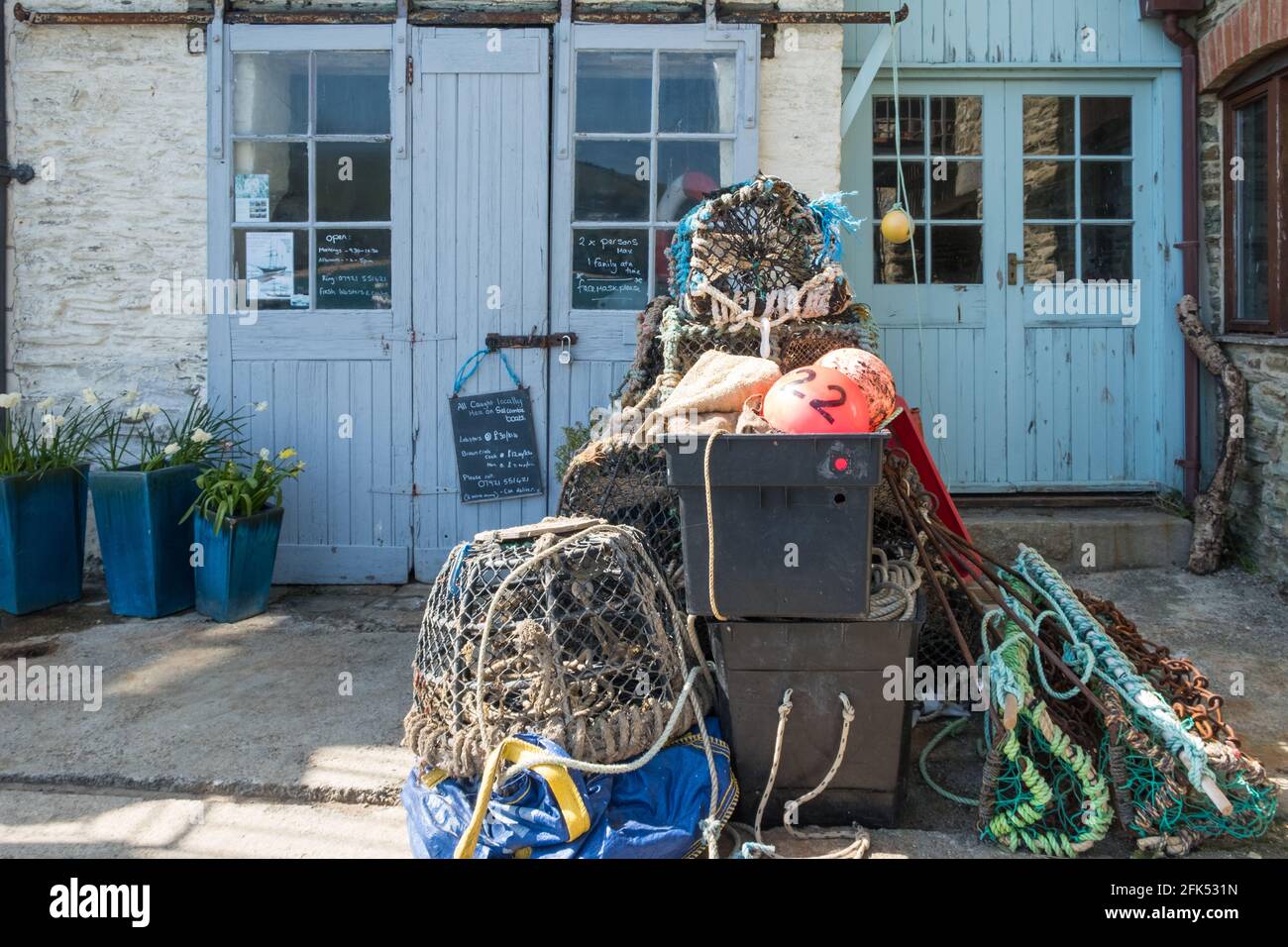 Krabben- und Hummertöpfe stapelten sich am Kai vor einem Geschäft, in dem frische Krabben und Hummer in Salcombe, South Hams, Devon verkauft werden Stockfoto