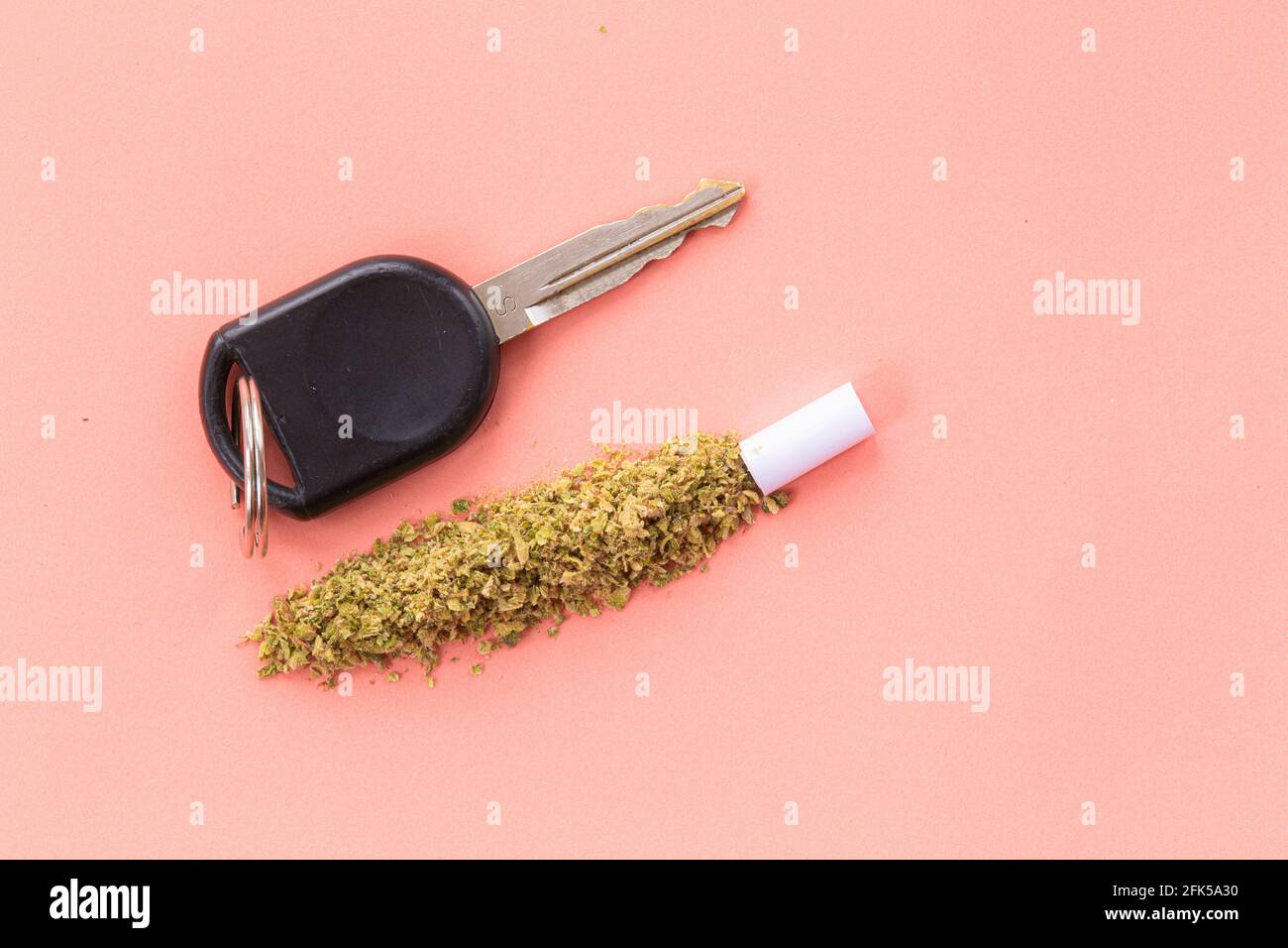 Fahren unter dem Einfluss von Cannabis oder Marihuana, hohes Fahren, Fahren bei eingeschränkter Fahrweise, Autoschlüssel mit Cannabis Stockfoto