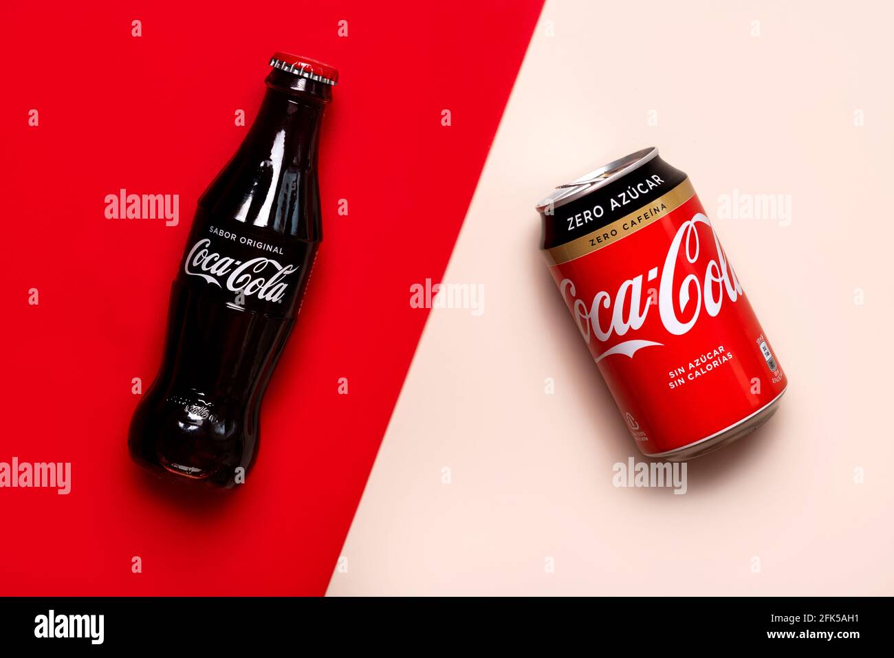 Klassische Glasflasche von Coca-Cola und Dose von Coca-Cola Zero Auf einem rot-weißen Hintergrund Stockfoto