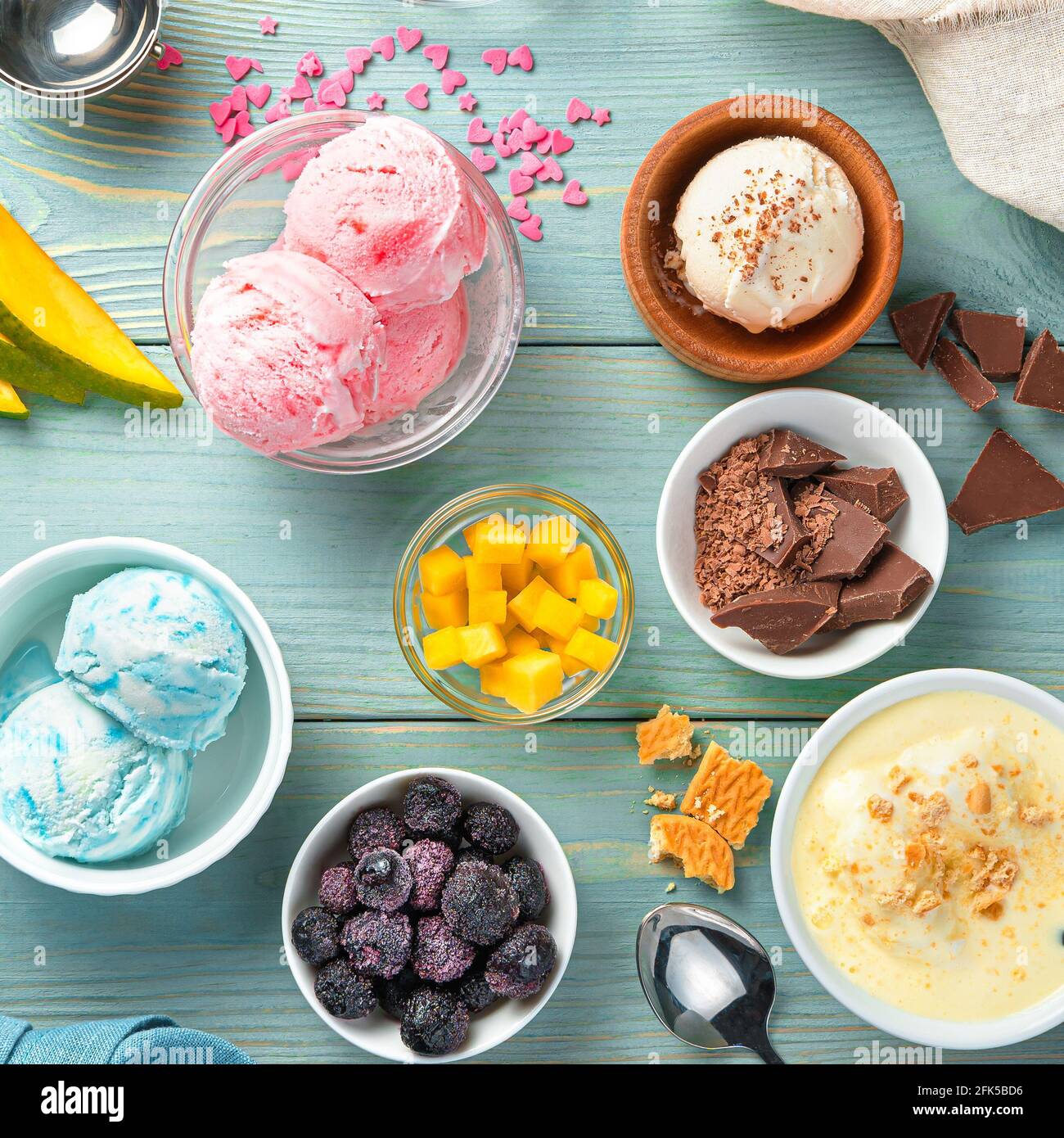 Creme, Himbeere, Brombeere und Mangoeis auf hellblauem Hintergrund. Stockfoto