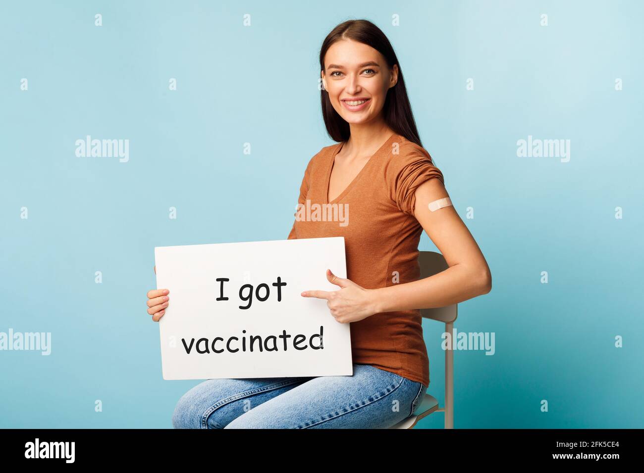 Pregnant Lady Holding Poster Ich wurde auf blauem Hintergrund geimpft Stockfoto