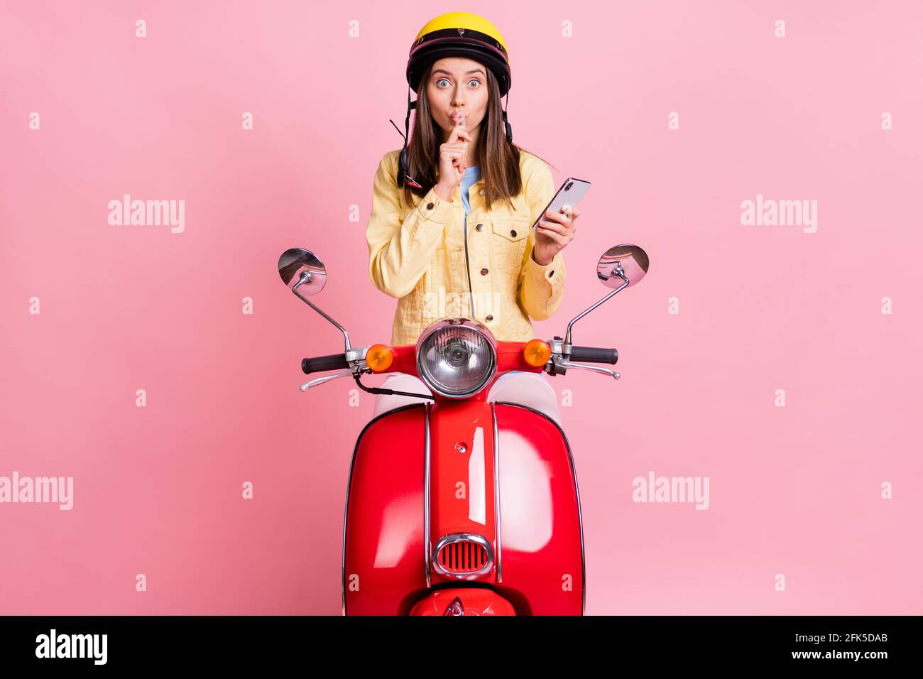 Foto von jungen neugierigen attraktiven Mädchen Frau pout Lippen halten Handy Hand Kinn isoliert auf rosa Farbhintergrund Stockfoto