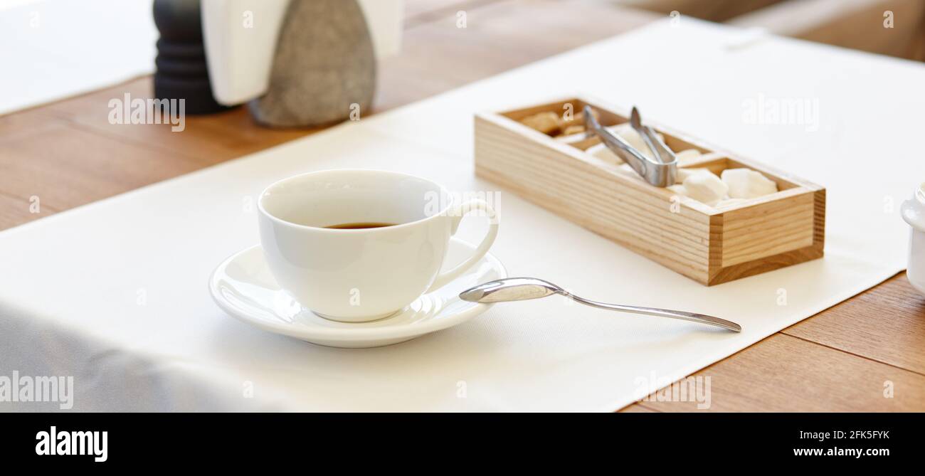 Heißer Kaffee in einer Tasse auf einem Holztisch. Modernes Design, Restaurant verwischen Hintergrund mit Bokeh-Bild Stockfoto