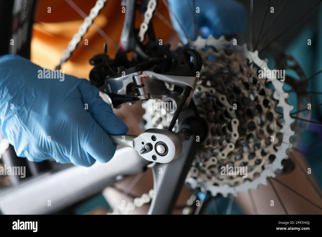 Vorarbeiter in Gummihandschuhen, die die Nahaufnahme des Fahrrads reparieren Stockfoto