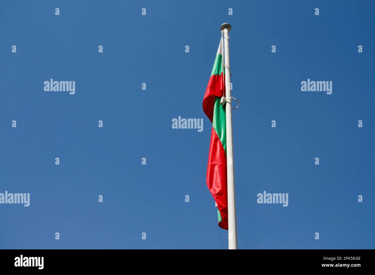 Die Flagge Bulgariens winkt auf einem Fahnenmast gegen den blauen Himmel Stockfoto