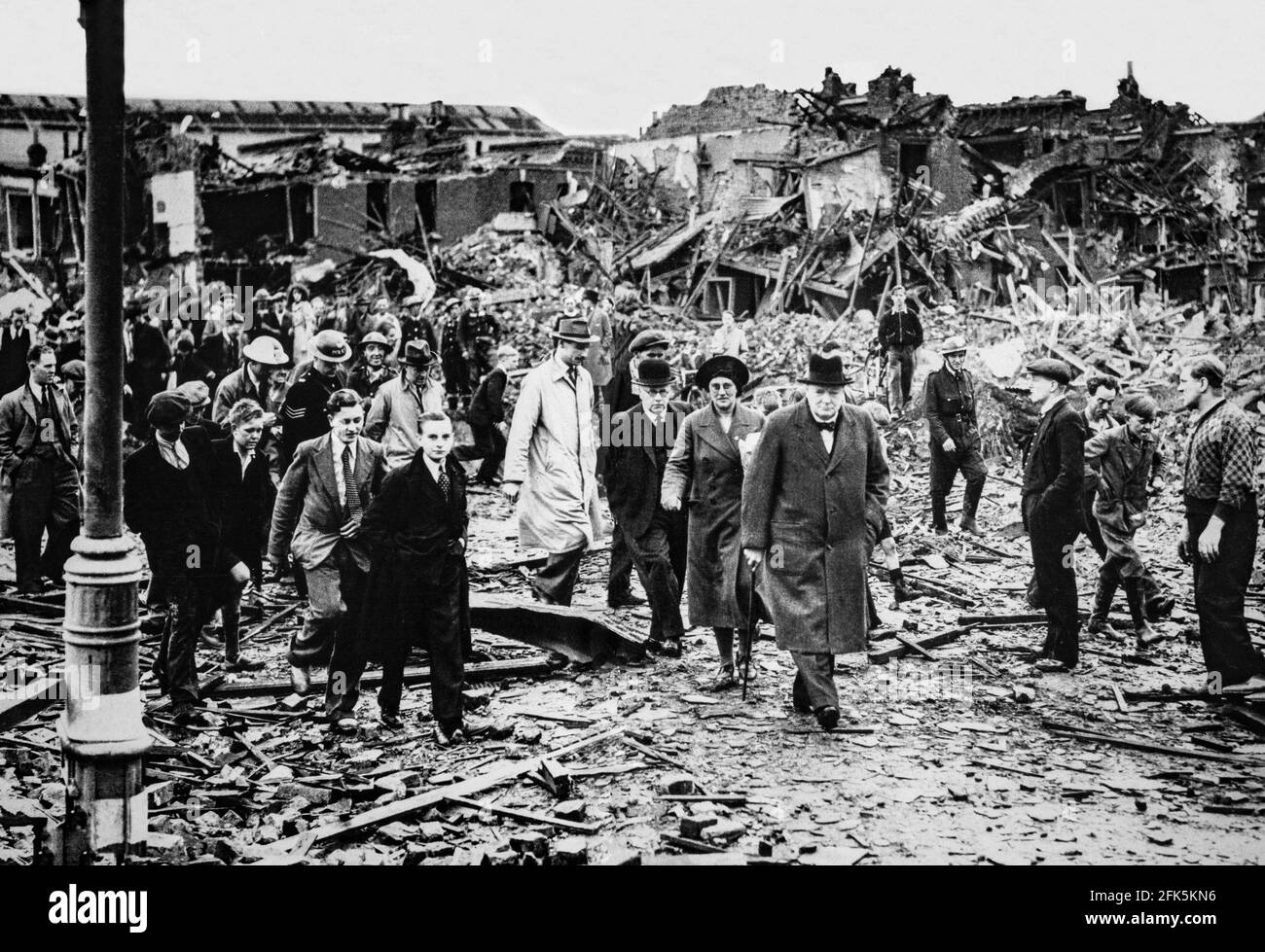 Nach einem schweren deutschen Luftangriff auf Battersea in London, England während des Blitzes von 1940, geht Premierminister Winston Churchill durch die Trümmer, um die Moral zu stärken. Stockfoto Nach einem schweren deutschen Luftangriff auf Battersea in London, England während des Blitzes von 1940, geht Premierminister Winston Churchill durch die Trümmer, um die Moral zu stärken. Stockfoto