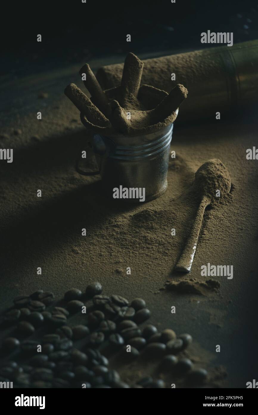 Kaffeetasse, umgeben von Kaffeepulver und einem Löffel Stockfoto