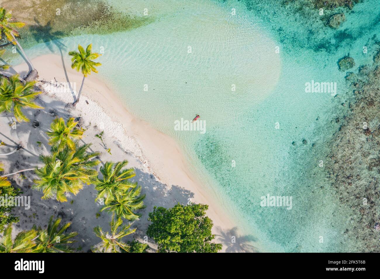 Strand Reise Urlaub top down Drohne Foto von Luxus tropisch Paradiesischer Strand mit eleganter Frau, die in perfektem türkisfarbenem Wasser schwimmend ist Im Korallenriff Stockfoto