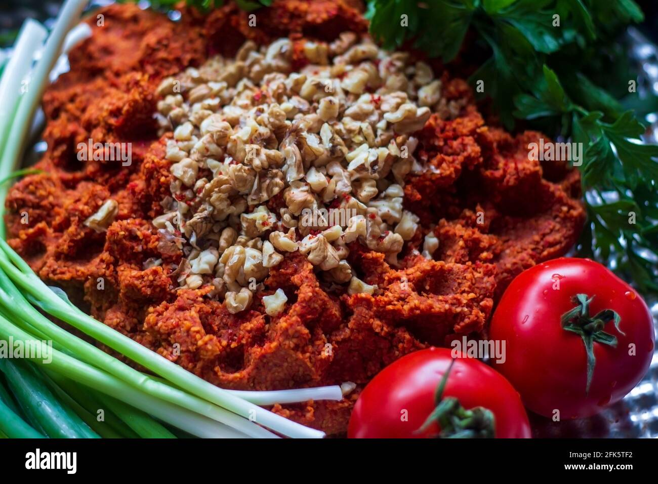 Türkische rohe Fleischbällchen (Cig kofte; ein rohes Fleischgericht) mit Salat und Zwiebeln. Nahaufnahme Stockfoto