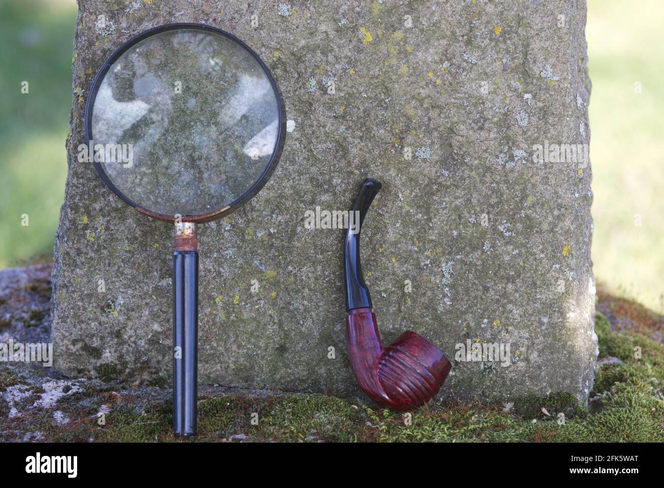 Lupe und Pfeife am Grab von Sir Arthur Conan Doyle in All Saints Churchyard, Minstead, New Forest District, Hampshire, England Stockfoto