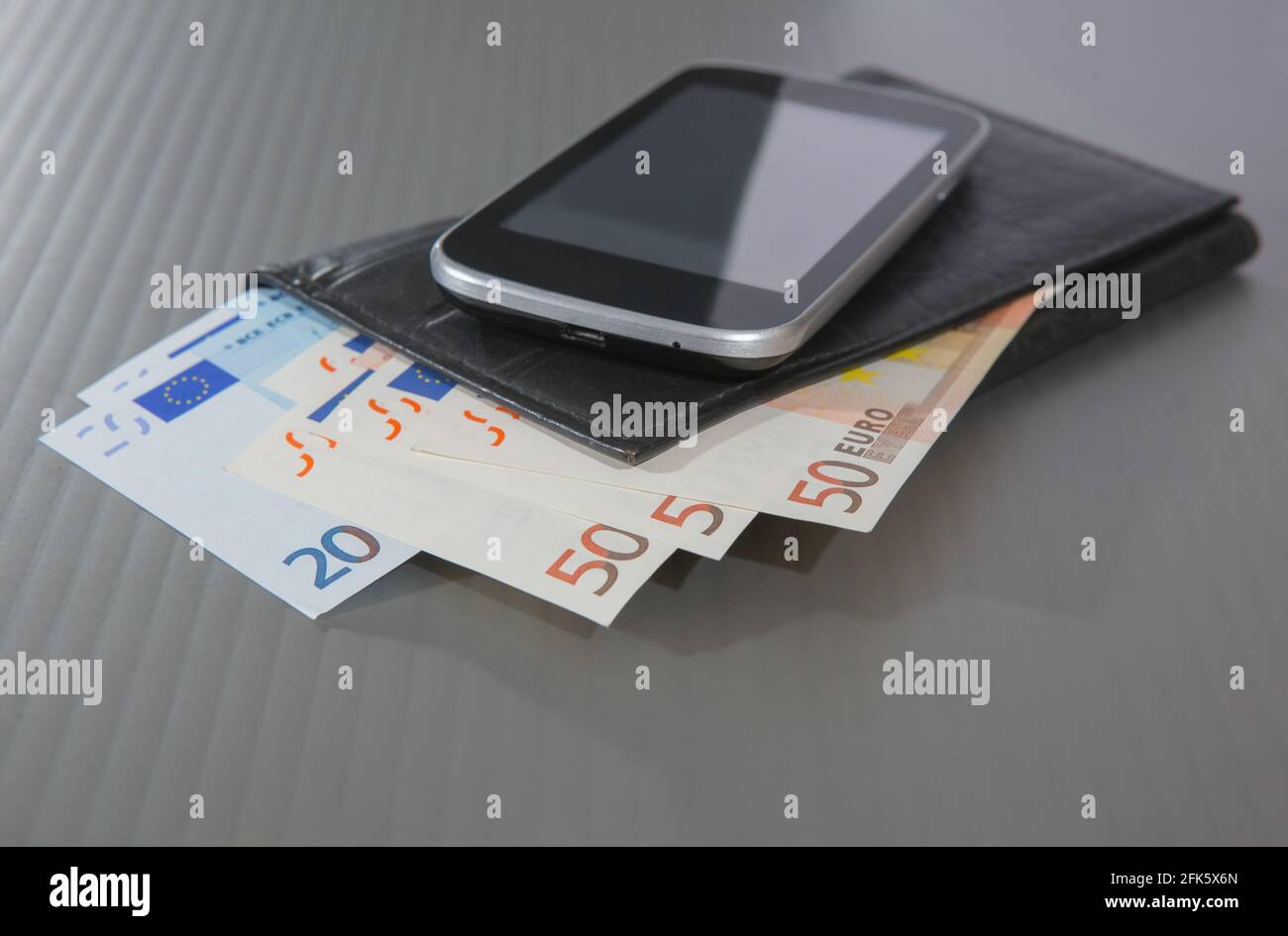 Euro banknote Geldbeutel und Smartphone auf grauem Hintergrund Stockfoto