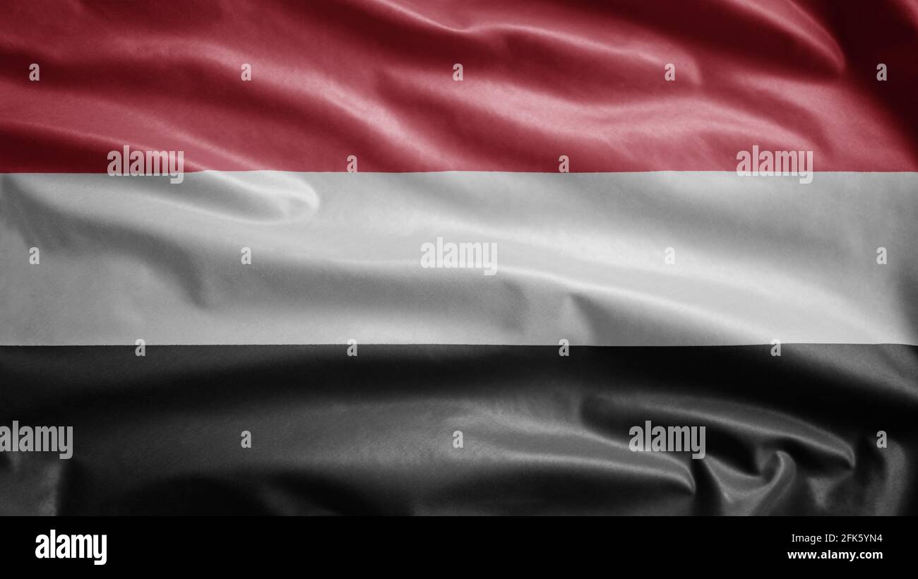 Jemenitische Flagge winkt im Wind. Nahaufnahme des Jemen Banner weht, weiche und glatte Seide. Stoff Stoff Textur Fähnrich Hintergrund. Stockfoto