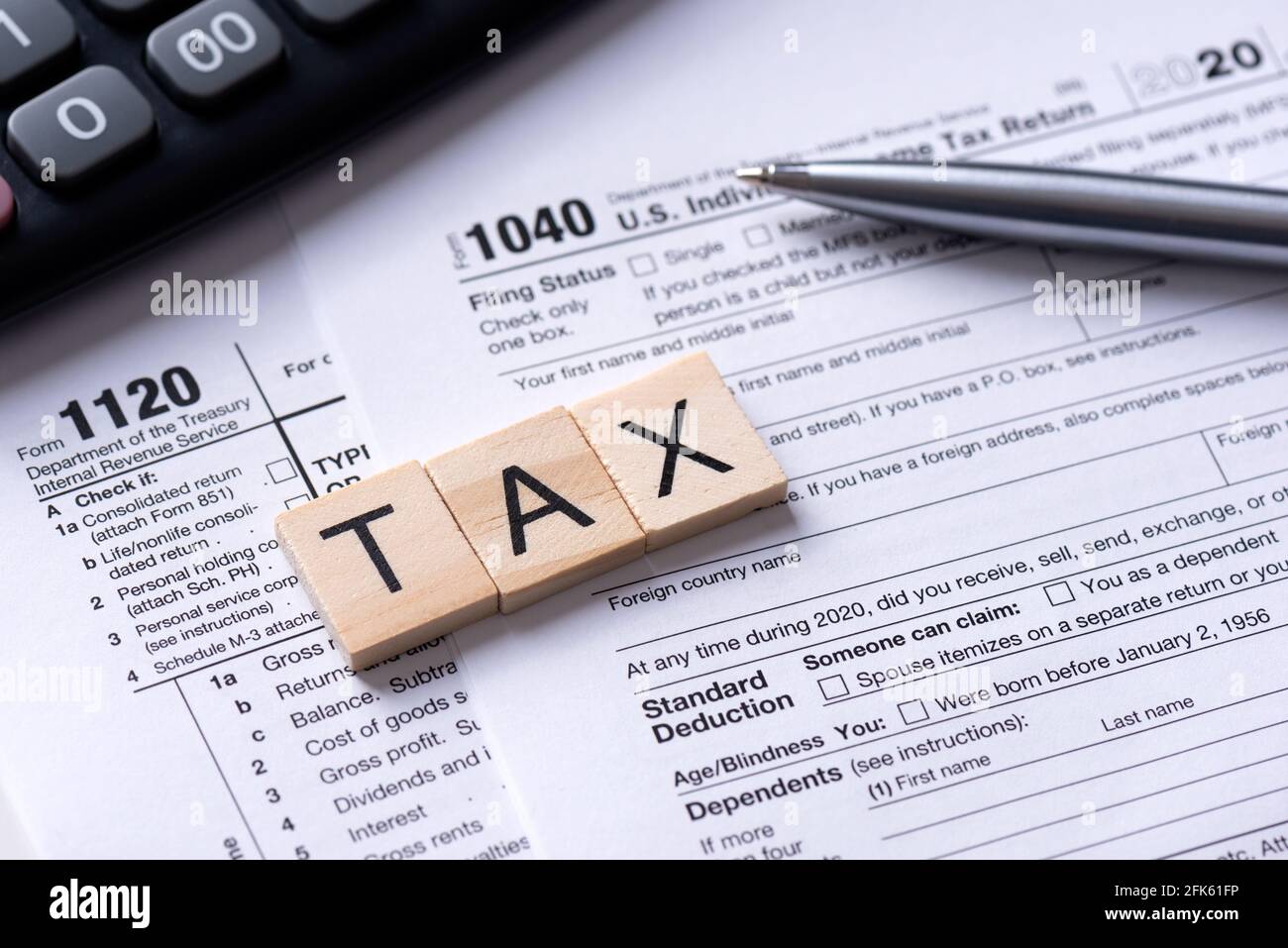 Steuerwort aus Holzfliesen. US-Steuerformular an der Rezeption. Konzept der Unternehmenssteuer-Einkünfte Stockfoto