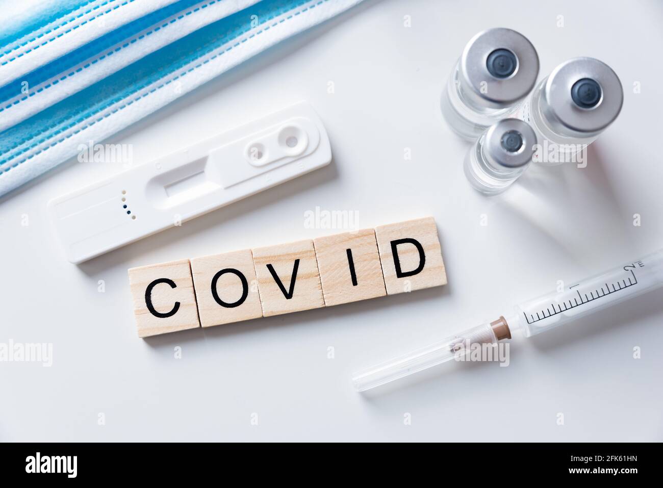 Impfkonzept, Coronavirus-Impfung, medizinische Ausrüstung, COVID-Wort aus Holzfliesen Stockfoto