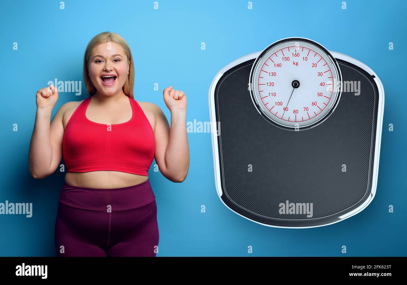 Fat Mädchen tut Fitness-Studio zu Hause mit zufriedenen Ausdruck, weil sie ihr Gewicht zu verringern. Lila Hintergrund Stockfoto