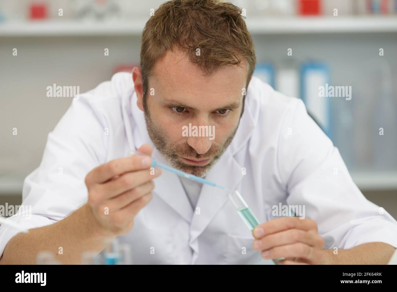 Professioneller männlicher Laborarbeiter, der mit Pipette arbeitet Stockfoto