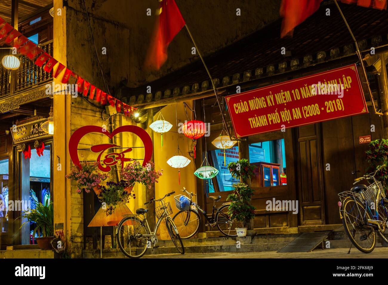 Stimmungsvolles Außengeschäft mit Fahrrädern und bunten Laternen, Altstadt, Hoi an, Vietnam Stockfoto