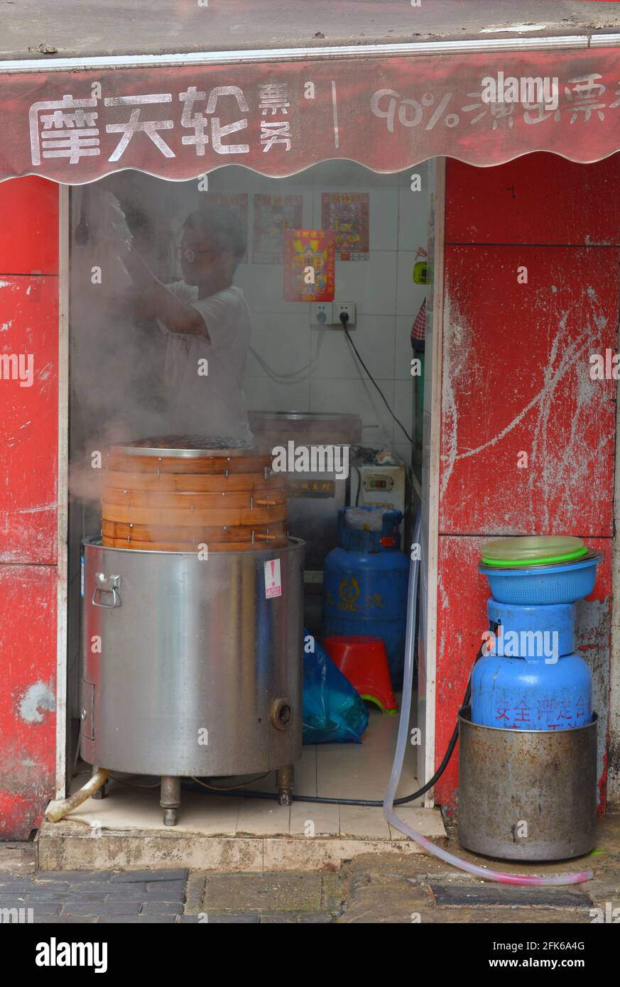 Kleiner Laden mit gedämpften Brötchen auf den Straßen von Shanghai. Mit traditionellen alten Bambusdampfern. Stockfoto