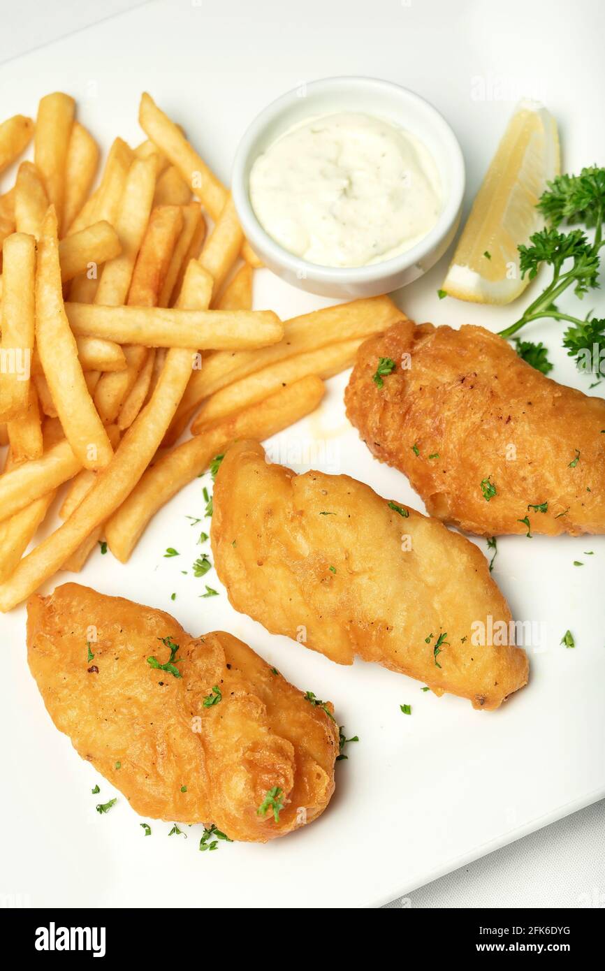 traditionelle britische Fish & Chips Mahlzeit auf weißem Teller Stockfoto