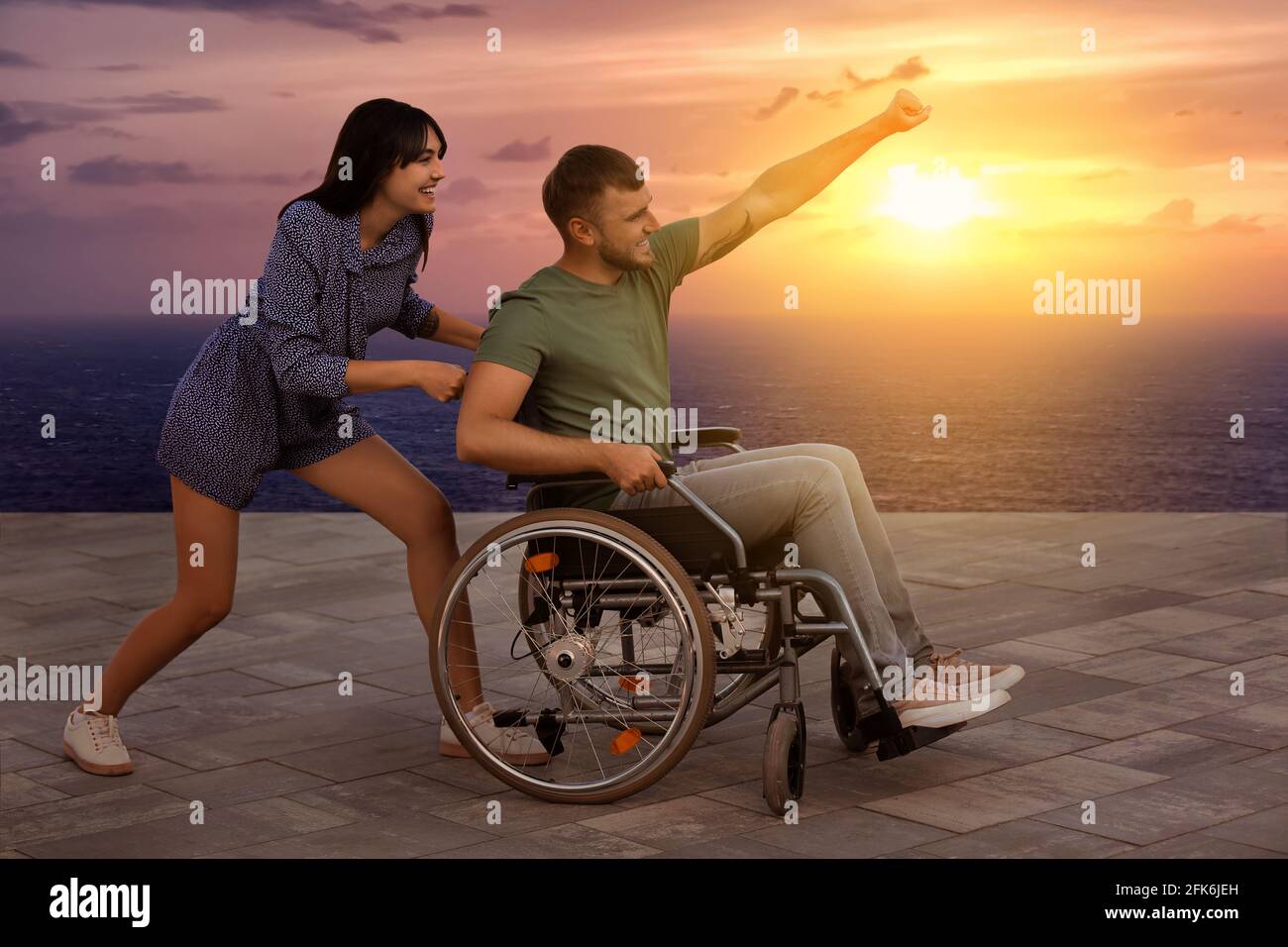 Glückliche junge Mann im Rollstuhl und seine Frau im Freien Stockfoto