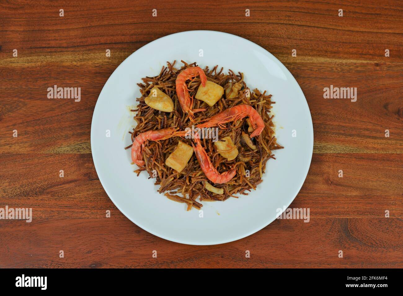 Teller mit spanischer Fischfidua auf einem Holztisch Stockfoto