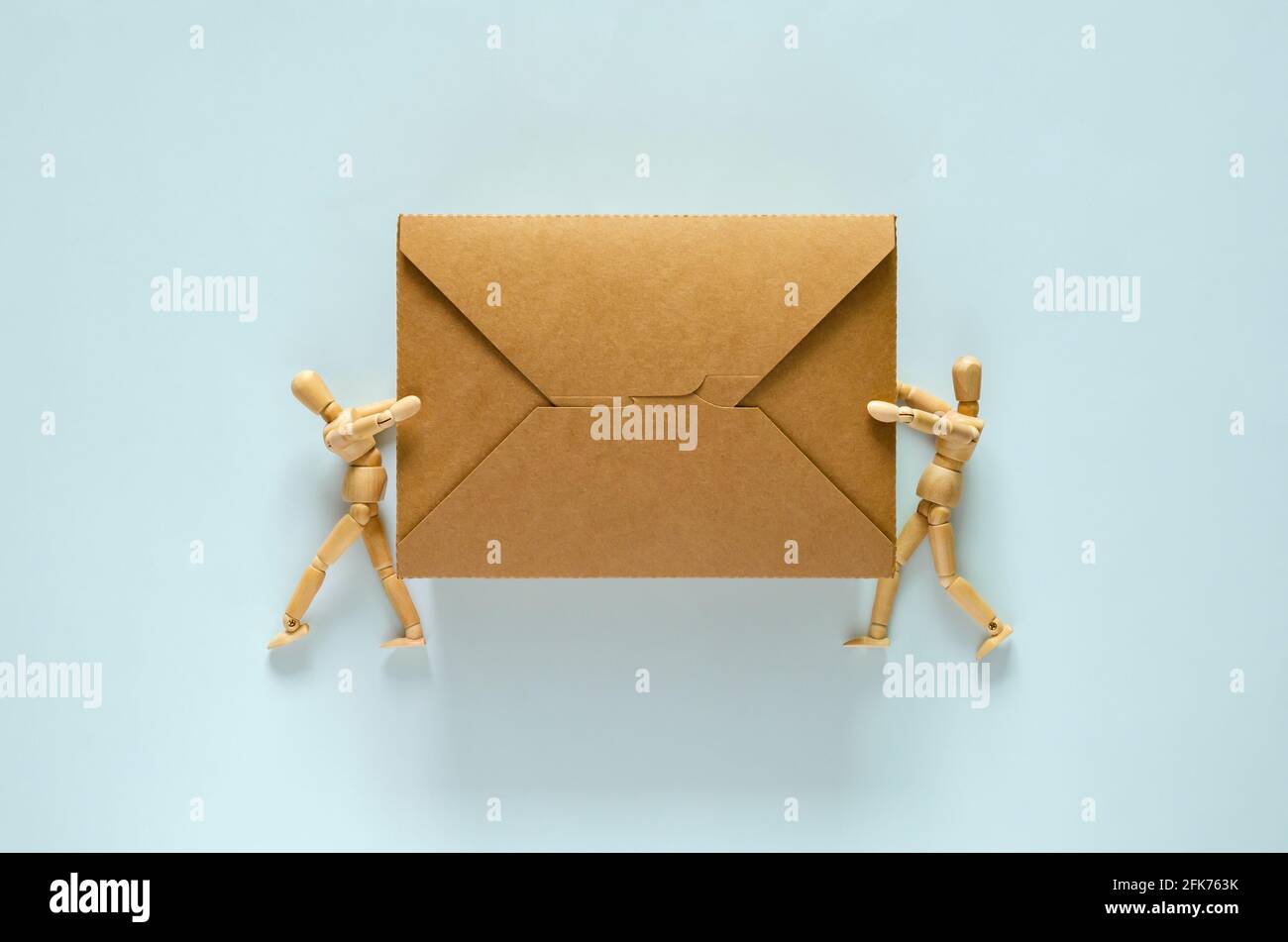 Zwei Holzmodelle, die eine Einweg-, kompostierbare Papier-Lebensmittelbox für das Weltumweltkonzept halten. Stockfoto