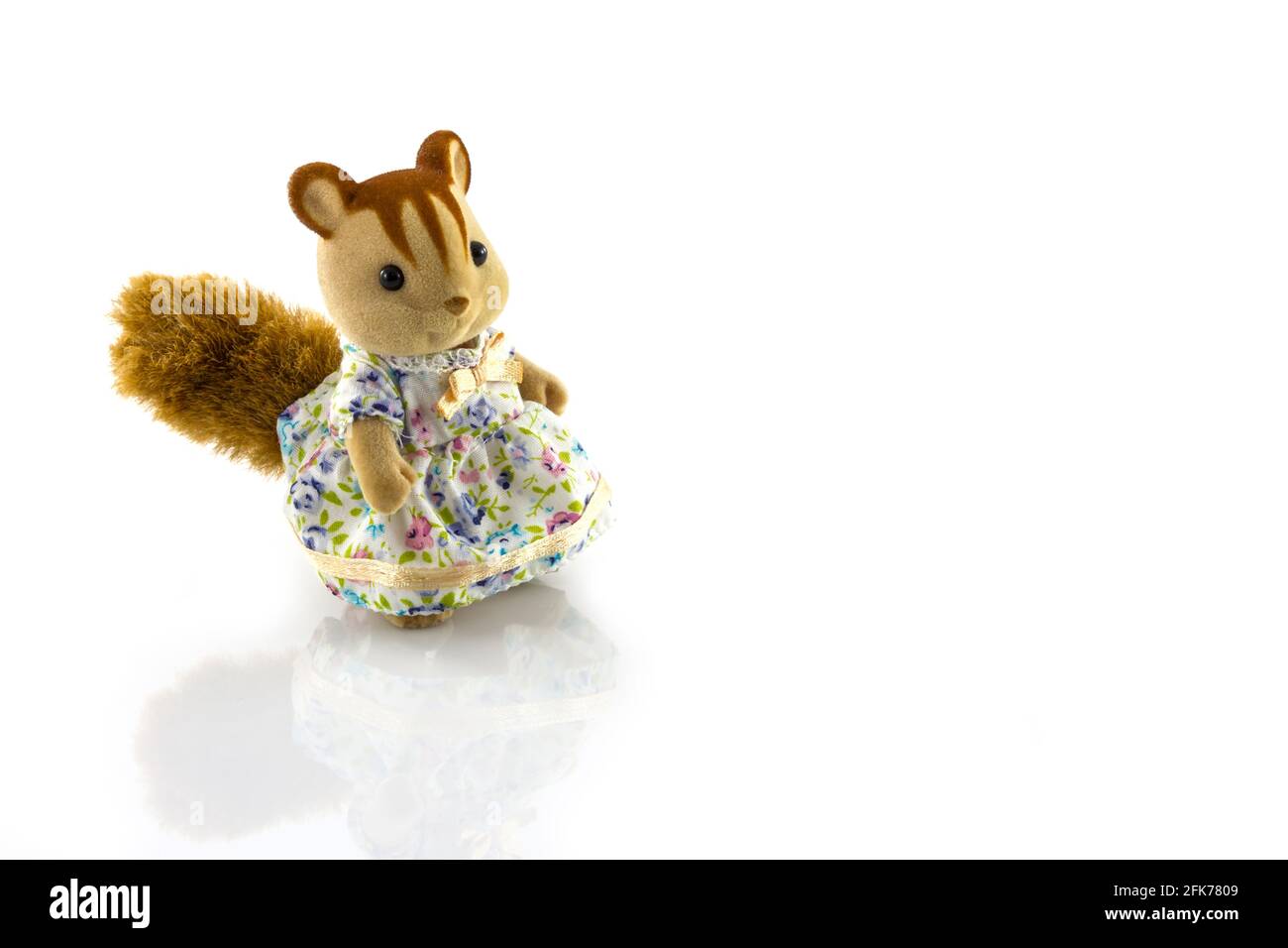 Mädchen Eichhörnchen Spielzeug trägt Kleid auf weißem Hintergrund Stockfoto