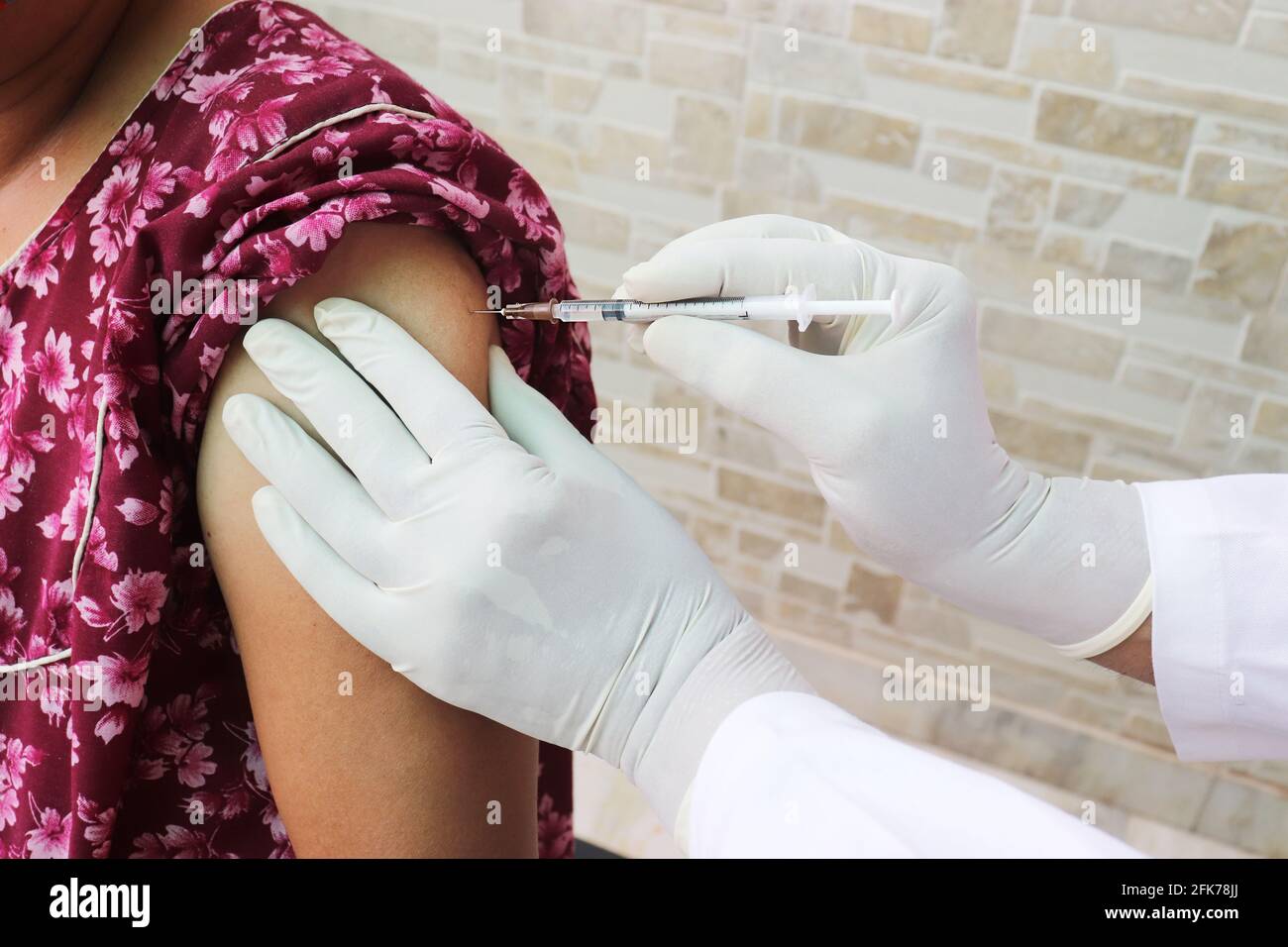 Nahaufnahme des Arztes mit einer Spritze zur Injektion eines Covid-19- oder Coronavirus-Impfstoffs an einen Patienten, COVISHIELD/COVAXIN Dose. Stockfoto