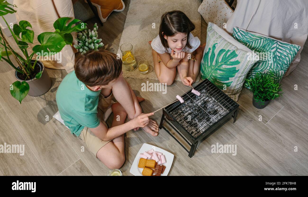 Draufsicht auf Brüder, die zu Hause kampieren und auf Sumpfgebieten toasten Stockfoto