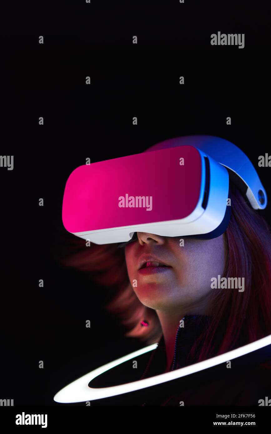 Frau verwendet Headset für virtuelle Realität. Konzept der virtuellen Realität, Simulation, Gaming und Zukunftstechnologie. Stockfoto