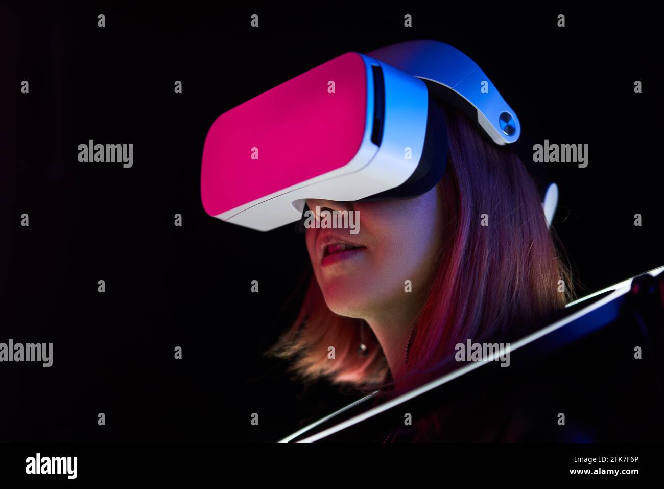 Frau verwendet Headset für virtuelle Realität. Konzept der virtuellen Realität, Simulation, Gaming und Zukunftstechnologie. Stockfoto