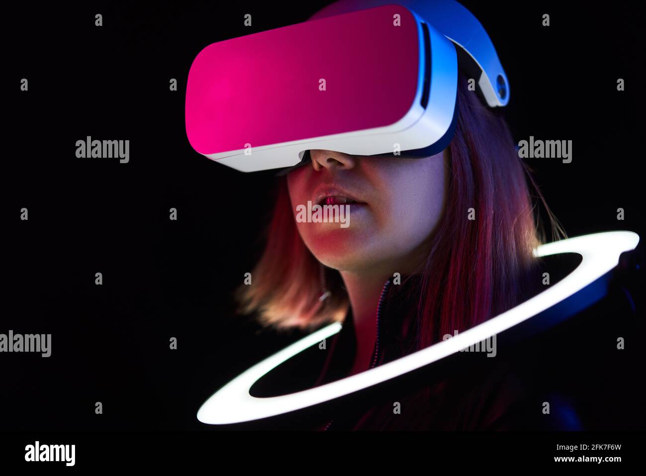 Frau verwendet Headset für virtuelle Realität. Konzept der virtuellen Realität, Simulation, Gaming und Zukunftstechnologie. Stockfoto