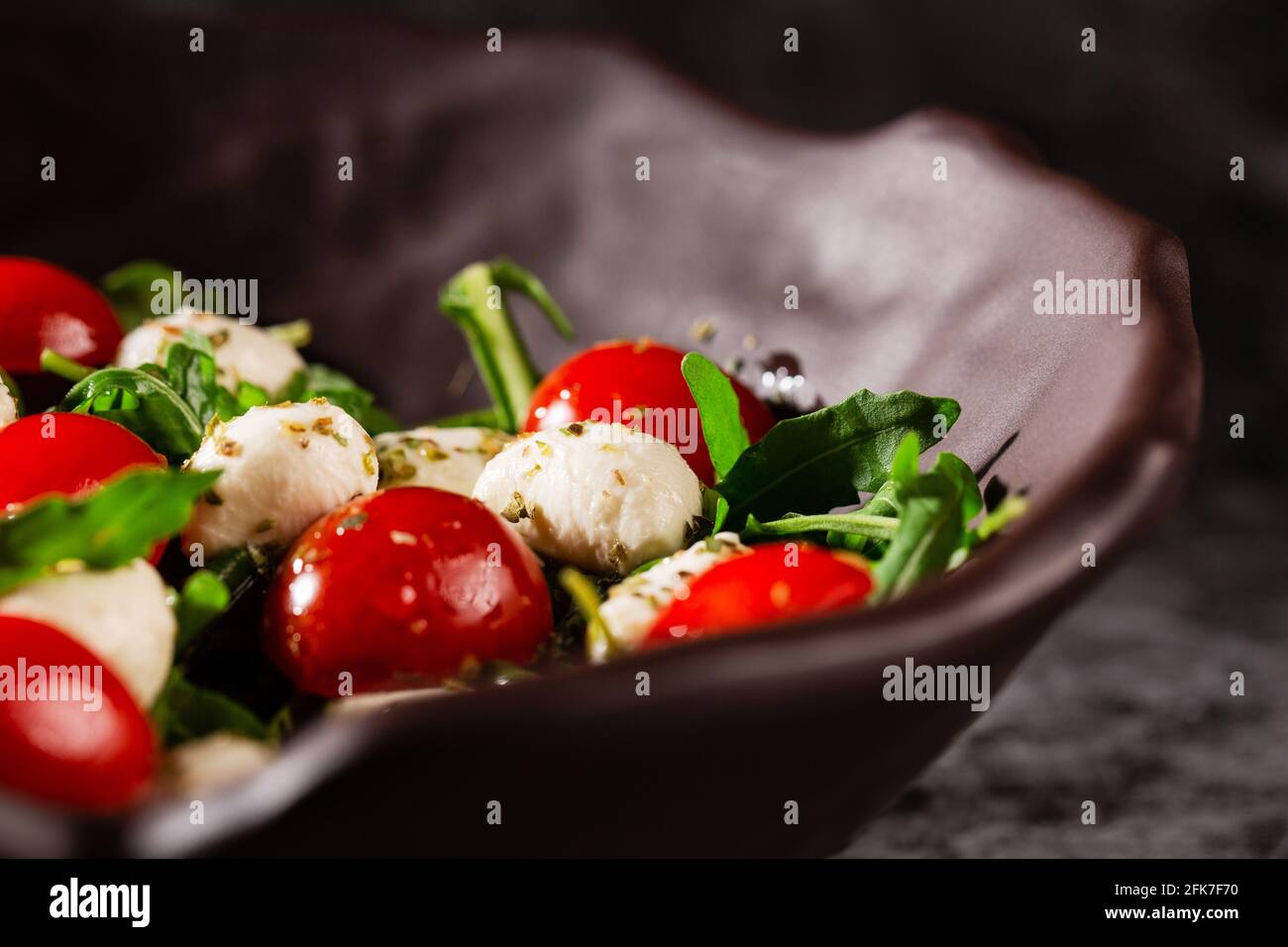 Caprese-Salat. Frische Rucola, Kirschtomaten, saftige Mini-Mozzarella und ein Dressing aus Orangano und Olivenöl Stockfoto