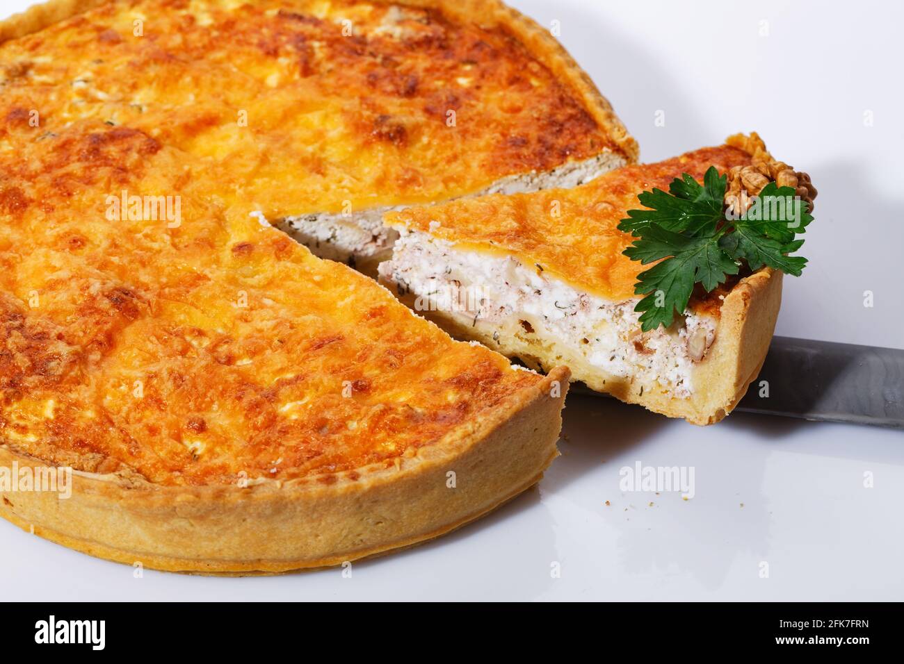 Nehmen von köstlichen Pilzkuchen mit einem Küchenteigling. Duftende Gemüsekuchen auf weißem Hintergrund. Aufwecken. Stockfoto