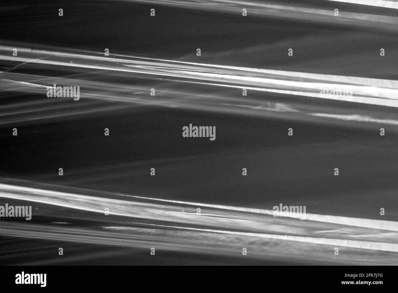 Abstrakt schwarz und weiß. Lichtreflexionen aus den Schichten einer Verpackung. Stockfoto