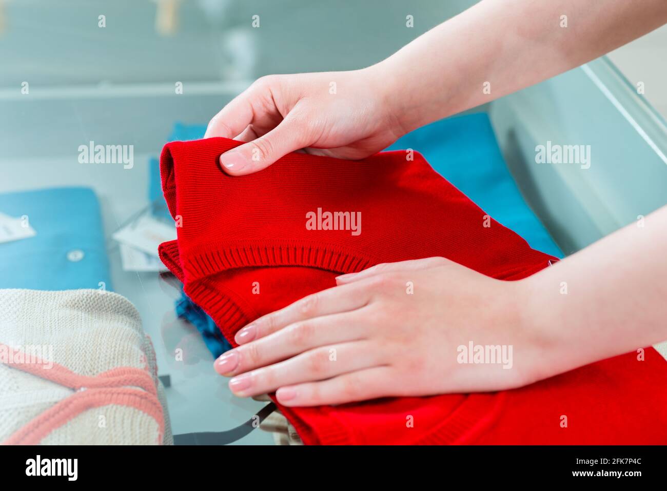 Junge Frau, die Spaß beim Fashion-Shopping in Boutique oder Laden, Rack, Kleidung, sie fühlt sich die Qualität Stockfoto