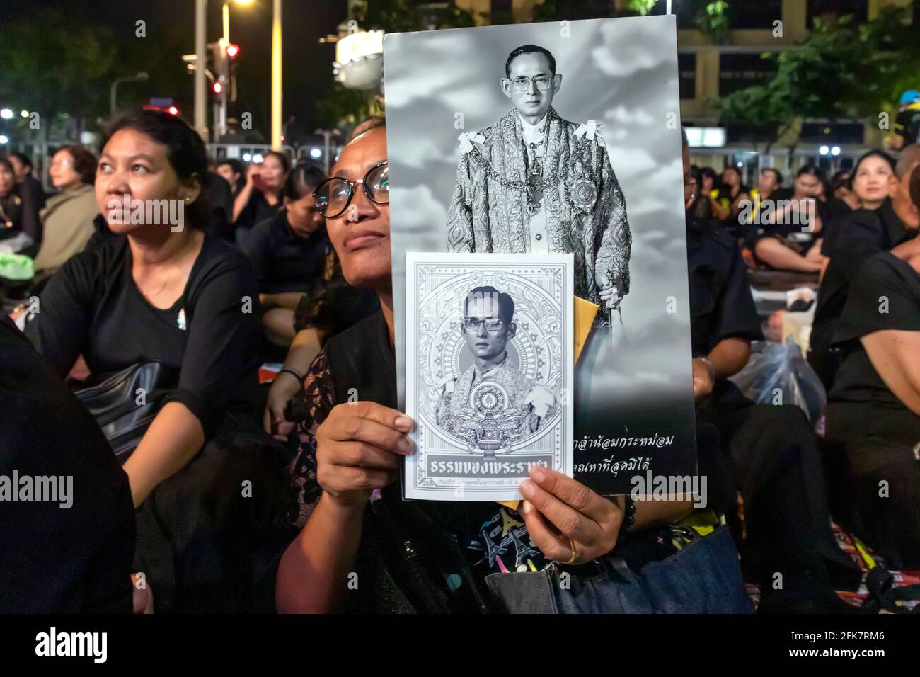 Trauernde in Schwarz mit Fotos von König Bhumibol bei der Trauerfeier in Bangkok, Thailand Stockfoto