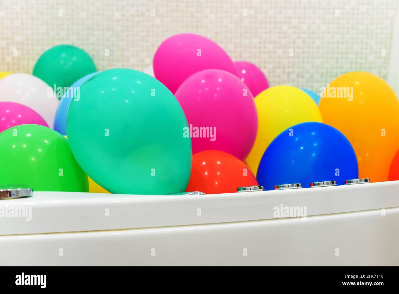 Die Badewanne ist mit bunten Luftballons gefüllt. Stockfoto