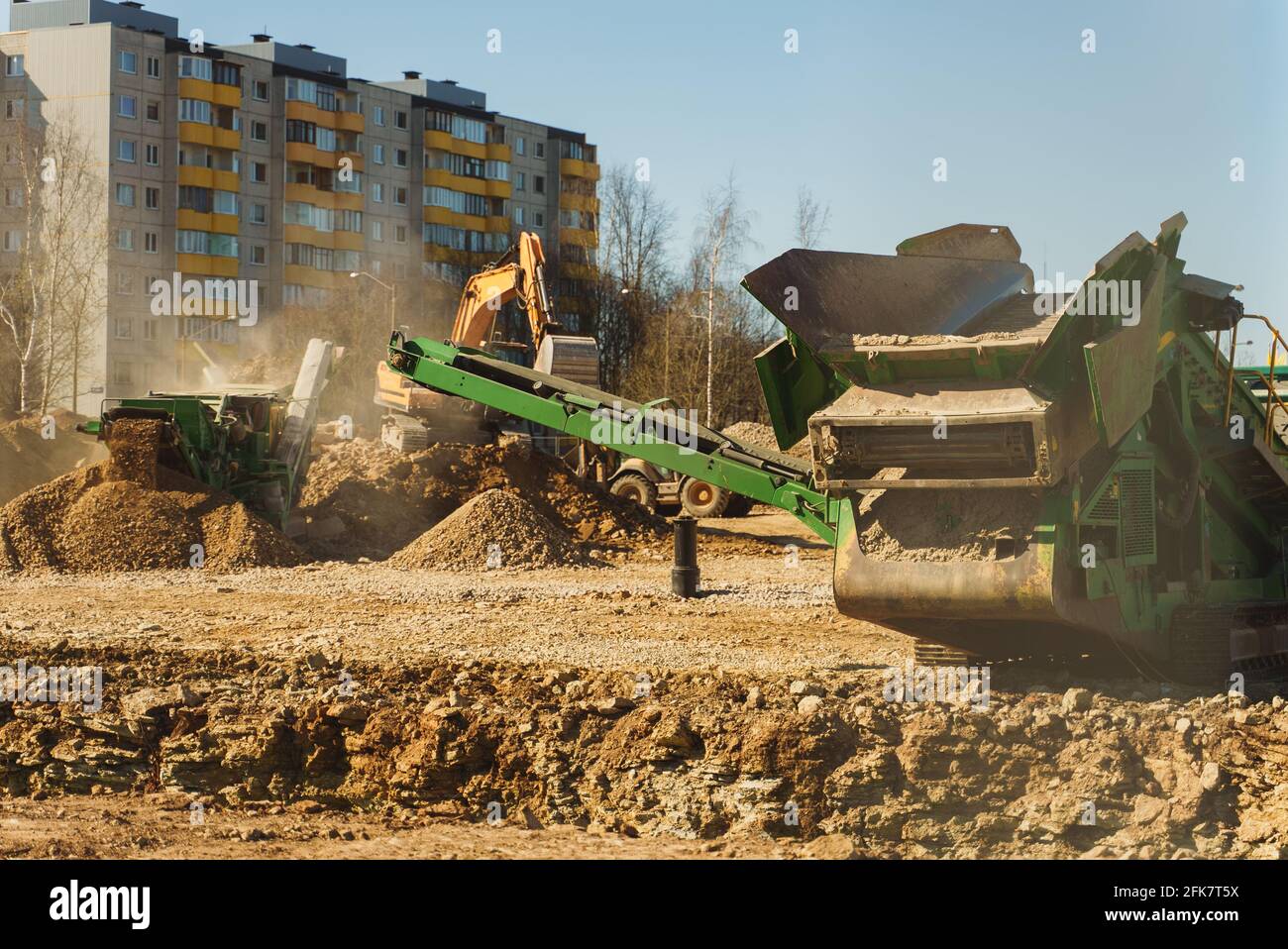 Bagger und Siebmaschine arbeiten auf der Baustelle. Stockfoto