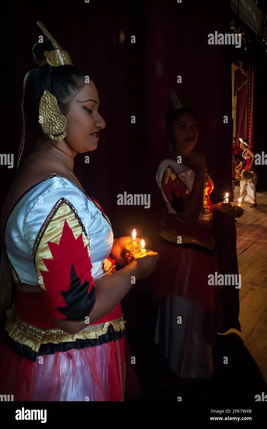 Kandy, Sri Lanka: Eine Tänzerin der Kandyan Arts Association versteckt sich hinter dem Vorhang, bevor sie die Bühne für die Abendshow betreten Stockfoto