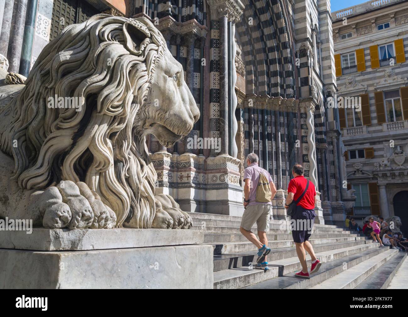 Genua, Ligurien, Italien. Gotische Kathedrale von San Lorenzo. Touristen, die Treppen hinauf zum Eingang am Löwen vorbei gehen. Stockfoto