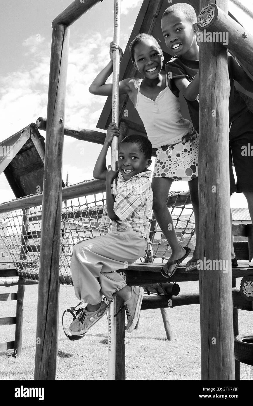 JOHANNESBURG, SÜDAFRIKA - 13. März 2021: Soweto, Südafrika - 11. Dezember 2010: Afrikanische Kinder spielen im Jungle Gym und anderen Parkgeräten im Lo Stockfoto