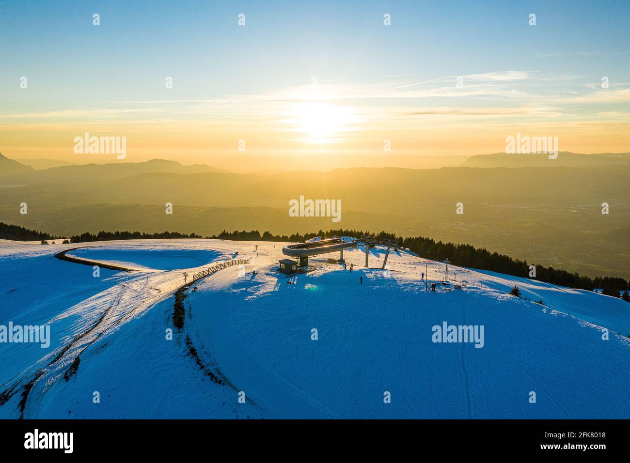 Luftaufnahme einer Skiliftstation auf einem verschneiten Berg bei Sonnenaufgang/Sonnenuntergang. Stockfoto
