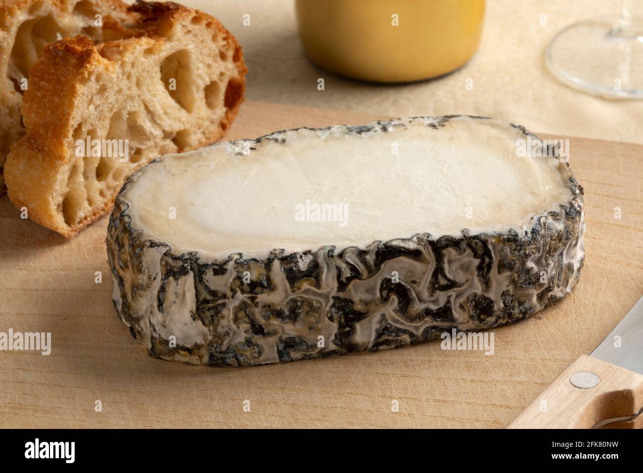 Ein Stück spanischen handwerklichen Monte Enebro-Käses aus nächster Nähe Ein Schneidbrett Stockfoto