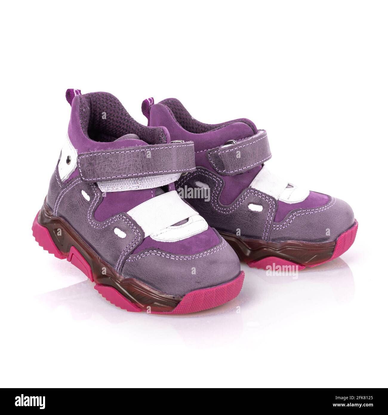 Lila Mädchen Stiefel im sportlichen Stil isoliert auf weißem Hintergrund. Paar neue moderne lila und rosa stilvolle Schuhe für Kinder mit Klettverschluss Stockfoto