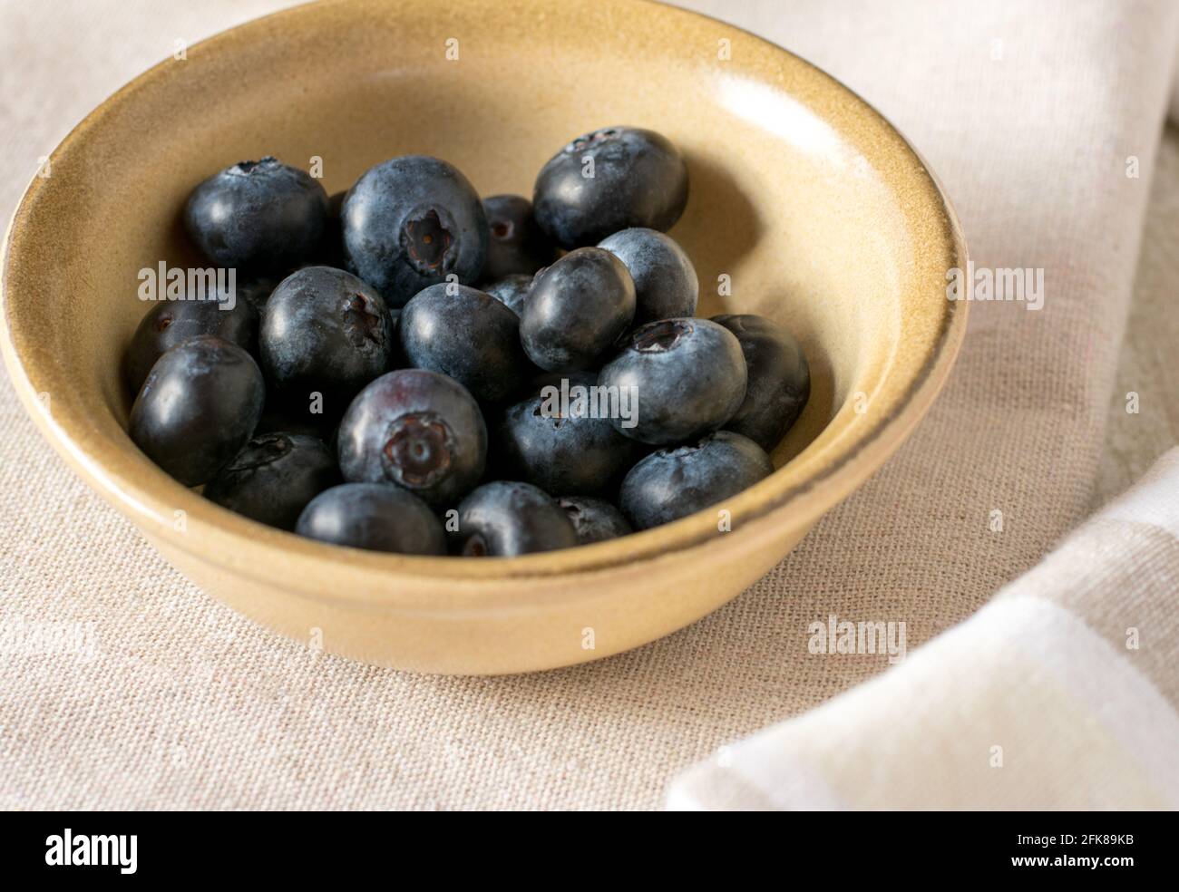 Eine kleine Schüssel mit frischen Heidelbeeren serviert isoliert auf Beige Hintergrund von oben Stockfoto