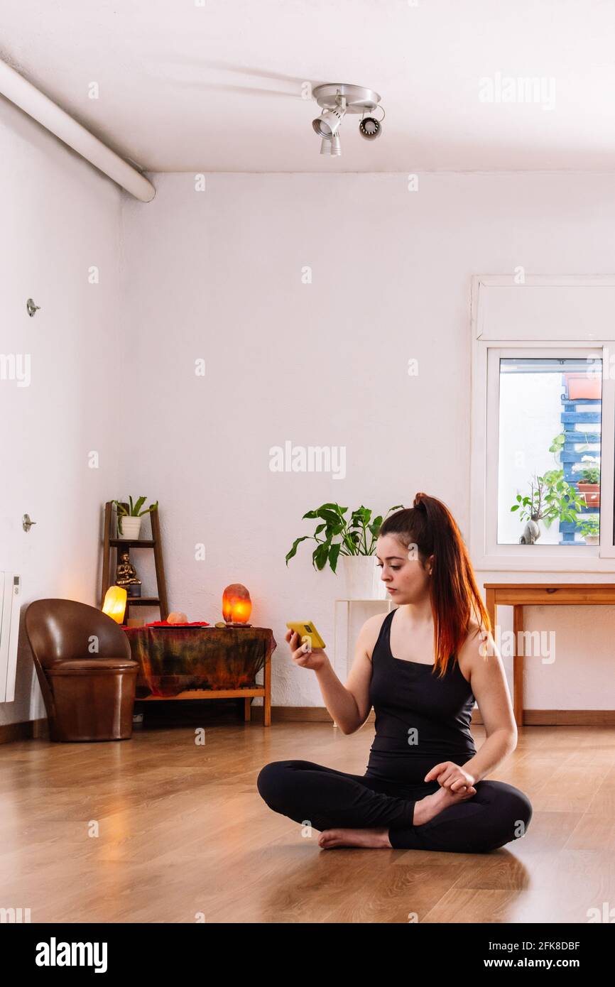 Fitness Frau sitzt und mit dem Handy Stockfoto